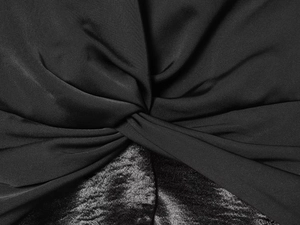 Detail of twisted black matte fabric spliced with glossy velvet on a V-neck shirt