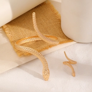 Macro detail of golden snake-shaped ring and arm cuff with lifelike scale texture