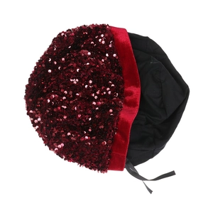 Close-up of red sequined beret with velvet brim and black satin ribbon detail