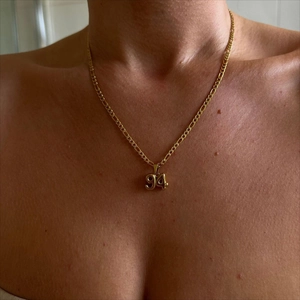 Golden 1994 number pendant necklace with high-shine metallic finish on a twist chain