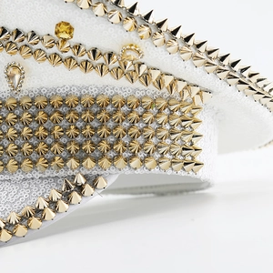 Close-up of a white sequined captain hat featuring gold studs and yellow rhinestones