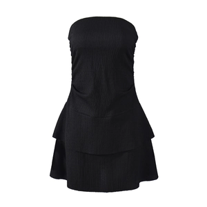 Detail of black strapless mini dress featuring textured pleated fabric and ruffled hemline