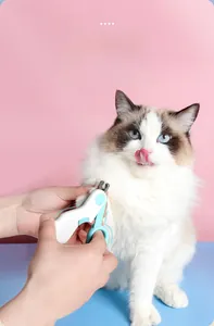 Ergonomic pet nail clipper trimming a cat's claws on a clean pink and blue background