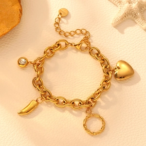 Golden stainless steel chain bracelet featuring heart and crystal charms on a white surface