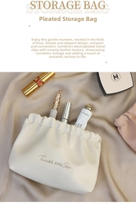 Detail of cream pleated PU makeup pouch with metal spring closure and star typography