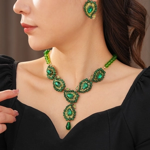 Detailansicht von Vintage Gold-Ohrringen und Halskette mit grünen Edelstein-Anhängern