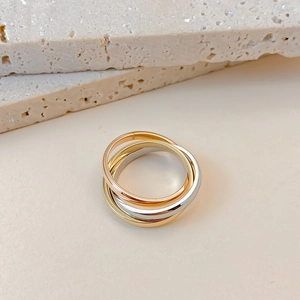 Macro detail of tricolor interlocking stainless steel rings with high polish finish