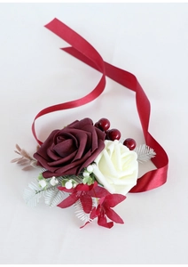 Close-up of artificial bridal wrist corsage with burgundy roses and silk ribbon straps