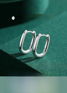 Macro shot of minimalist silver S925 sterling silver oval hoop earrings with polished finish