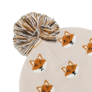 Close-up of beige knit hat with fox patterns and a colorful fluffy pom-pom detail