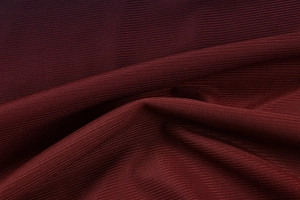 Texture macro du tissu en maille plissée bordeaux avec motif alvéolé détaillé