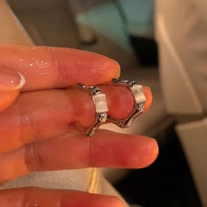 Détail de boucles d'oreilles en bambou argenté avec opale rectangulaire et zircones