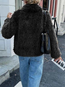 Street style view of deep brown fuzzy long sleeve coat paired with a black shoulder bag