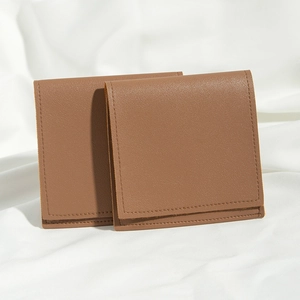 Detailed view of two premium brown faux leather drawstring pouches on white fabric