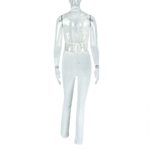 Detail of white halter neck top with open back tie design and slim-fit long pants