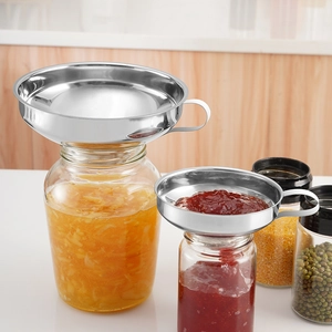 Golden stainless steel wide-mouth funnels for canning jams and beans in a kitchen setting