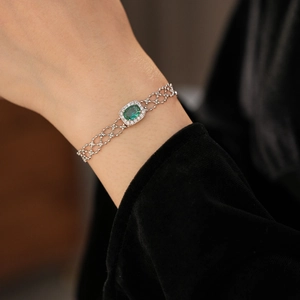Close-up of vintage silver bracelet with green oval zircon and velvet sleeve detail