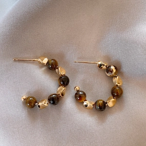 18K gold plated tiger eye stone C-shaped hoop earrings on elegant silk background