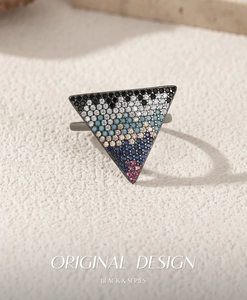 Macro shot of triangle ring featuring multicolor gradient crystals and vintage dark finish