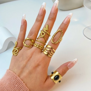 Detail of stacked 18K gold plated stainless steel rings including snake and gem designs