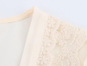 Détail de l'encolure en V élégante avec dentelle et tissu en mousseline lisse