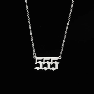 Macro shot of gothic 555 angel number pendant on a stainless steel link chain