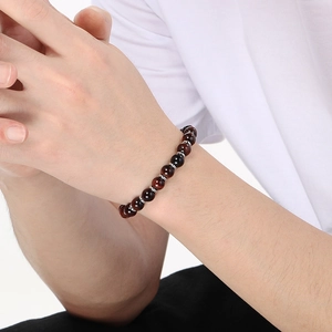 Close-up of a red-brown tiger eye stone beaded bracelet with metal spacers on a wrist