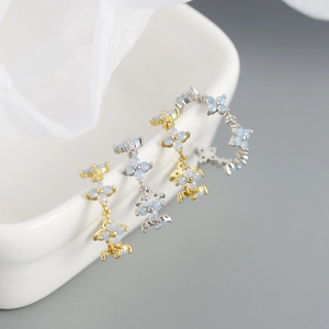 Detail of s925 silver four-leaf clover rings with light blue opal-style floral stones
