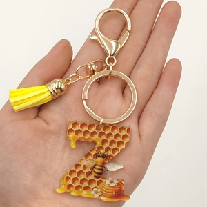 Detailed shot of letter Z acrylic keychain with bee patterns and a yellow tassel