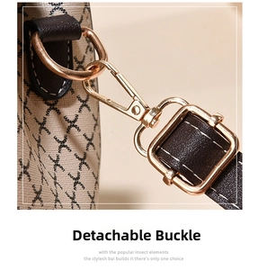 Macro shot of detachable gold-plated buckle on monogram print leather shoulder bag