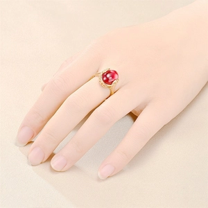 Vintage gold titanium steel ring with large oval red gemstone shown on model hand