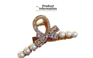 Detail of elegant gold-plated shark clip with white pearls and sparkling rhinestones