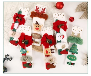 Flat lay of Christmas hair clip sets with Santa, reindeer and tree motifs for kids