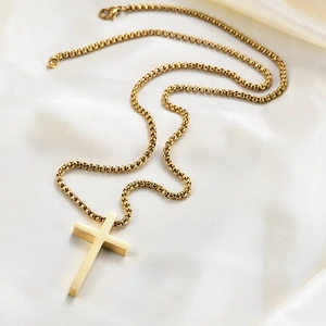 Vue détaillée du pendentif croix en or poli sur une chaîne maille vénitienne et soie