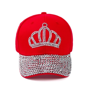 Close-up of a red baseball cap with crystal crown design and rhinestone-studded brim detail