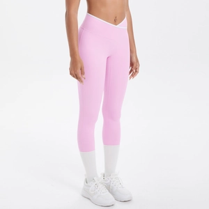 Vue détaillée du legging de yoga rose montrant la taille croisée et la bordure blanche