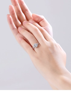Detailed view of S925 silver ring featuring crossover band and halo set round moissanite