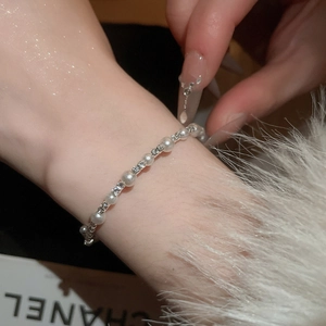 Macro view of double-layer pearl bracelet with sparkling diamond-set metal spacers