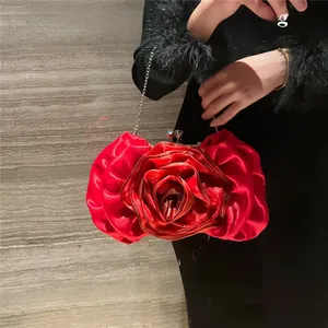 Close-up of 3D red rose evening bag with satin finish and silver chain strap