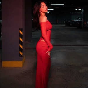 Detail of red off-shoulder long sleeve dress with waist cutout in a city garage
