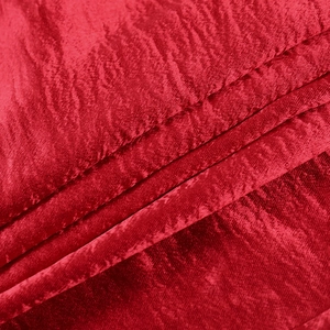 Macro shot of red satin fabric texture with elegant pleated details and smooth silk finish