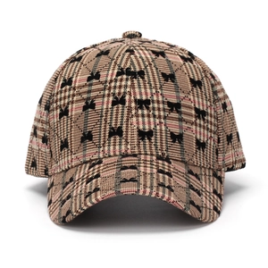 Brown plaid baseball cap featuring black bow patterns and curved brim for women