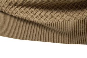Close-up of khaki cotton sweater showing honeycomb texture and ribbed hem detail