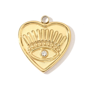 Gros plan d'un pendentif coeur doré avec gravure d'œil et détail en cristal poli