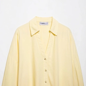 Linen blend wide sleeve shirt in light yellow with V-neckline and resin button details