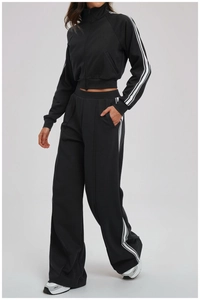 Detail of classic black sports set with side white stripes on jacket sleeves and pants
