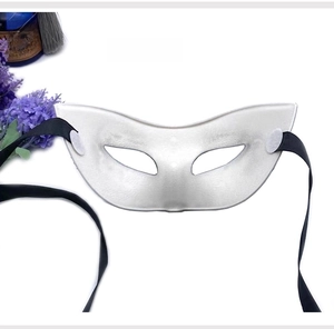 Rear view of the white masquerade eye mask showing black ribbon ties and structure