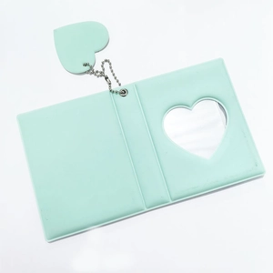 Close-up of mint green 3-inch photo album with heart hollow window and matching heart charm