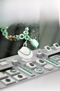 Elegant tiered display stand featuring assorted jade necklaces, bracelets, and rings