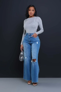 Detailed view of high-waist distressed wide-leg denim jeans with ripped knee design